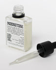 Womb Cult moonstone oil bottle with a dropper, featuring a dark glass container and moonstone label on a white background.